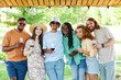 © Seventyfour - Vibrant portrait of diverse group of friends looking at camera and holding wine glasses while enjoying outdoor party in Summer