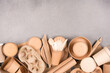 Paper utensils bundle, ecological tableware - paper cups, food containers, bags and wooden bamboo cutlery over gray concrete background with copy space. Sustainable take away food packaging concept