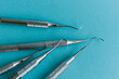 Lot of dental periodontal scalers on blue background