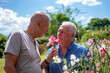 Senior male couple smelling flowers