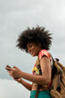 Young woman with backpack using phone