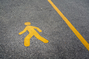 A pedestrain walking lane with human icon on asphalt road surface. Transportation symbol for safety background concept.