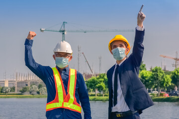 Wall Mural - Asian engineer and foreman worker with touch pad discuss, plan working for the outdoors building construction site.