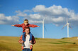 Leinwandbild Motiv Eco activists man and child on background of power stations for renewable electric energy production. People and windmills. High wind turbines for generation electricity. Green energy