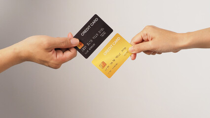Two hands is hold black and gold credit card on white background.