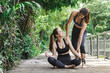 © gumpapa - two happy smiling beautiful female teenager friends practice yoga exercises in outdoor city park at weekend morning. woman yoga  trainer training young teen. healthy exercise sport and lifestyle..