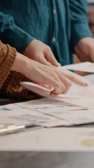 Poster - close up of business people looking at papers with rate charts to plan project and presentation at d