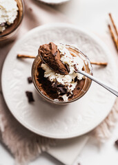 chocolate cake with coffee 
chocolate mousse cream in a glass cup on a white background with whipped cream and salty sticks snack snack sweet dessert