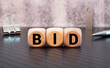 three wooden cubes with letters BID, on white table and diagram, business concept.