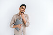 © Kateryna - Attractive modern arabian or indian guy in stylish casual shirt, freelancer or student, holding a laptop, standing on a white isolated background, looks at camera, smiles friendly. Copy space concept