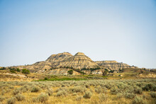 Badlands Formation Rises Out Of Grassy Prairie