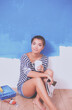 © lenets_tan - Portrait of female painter sitting on floor near wall after painting