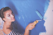 © lenets_tan - Beautiful young woman doing wall painting , standing