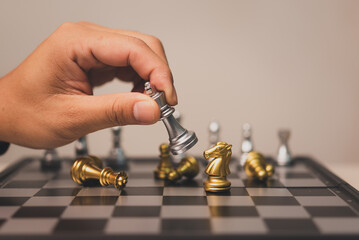 Hand man holding chess game stand on chessboard.Business strategy teamwork success investment concept.