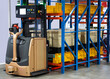 Automated Guided Vehicles (AGV) forklift lifting carton in modern warehouse.