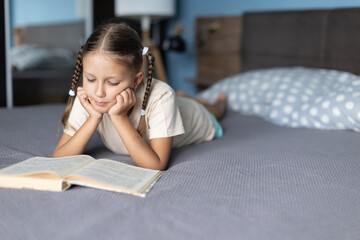 girl child reads a book in the room