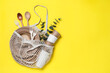 Leinwandbild Motiv Net bag with different eco items on yellow background, top view and space for text. Recycling concept