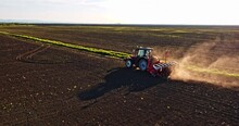 Farmer In Tractor Seeding Soybeans At Industrial Agricultural Farm