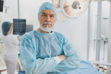 Wall Mural - Professional surgeon standing in operating room with crossing hands, ready to work on patient