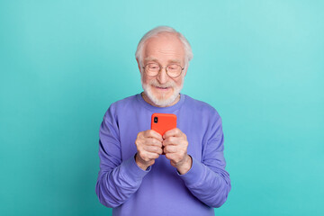 Wall Mural - Portrait of positive nice granddad hold use telephone chatting typing read news isolated on teal color background