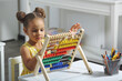 © ShunTerra - A Black African-American girl is ready for a math and arithmetic lesson with an abacus.