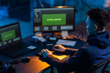 Poster - cybercrime, hacking and technology concept - male hacker in dark room writing code or using computer virus program for cyber attack