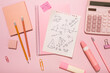 On a pink background, pink school supplies, a calculator, cheat sheets