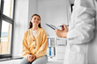 © Syda Productions - medicine, healthcare and people concept - female doctor with clipboard talking to smiling woman patient at hospital