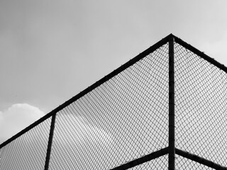 Wall Mural - silhouette wire mesh of fence with sky background, black and white style