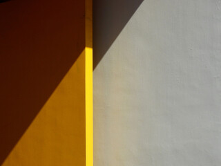 Wall Mural - yellow wood door and white concrete wall background with shadow of sunlight