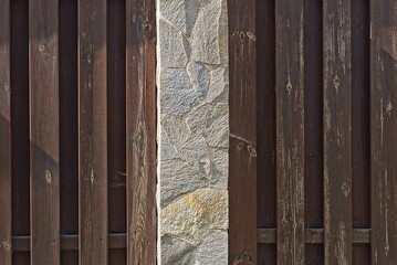 Sticker - texture of brown wooden boards and gray stone pillar in the wall of the fence