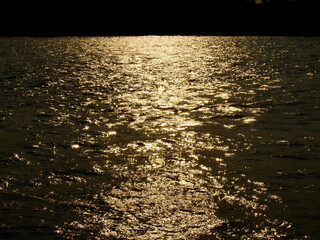 Poster - water wave in the river with reflection of sunlight at sunset