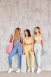 © standret - Young friends is with bag, mat and bottle of water. Beautiful women in sportive clothes is indoors in the studio