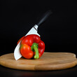 © Alexa Mat - Sharp knife cutting a red pepper with a knife on a cutboard.