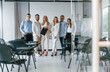 © standret - Standing and posing for a camera in the class. Group of professional business people is in the office