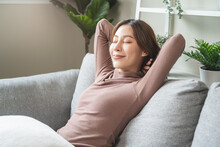 Calm Young Woman Relaxing On Sofa At Home In Weekend.
