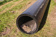 Front view on long black water HDPE pipe with blue stripe at construction site. Large Black Plastic Pipes for Water Supply. Welded joints on HDPE pipes.