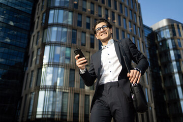 A businessman man uses the phone to work in the office in a business suit