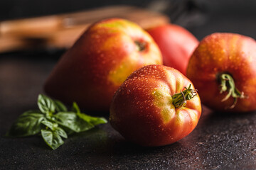 Wall Mural - Bull heart tomatoes on black table.