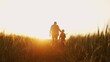 canvas print picture - Farmer and his son in front of a sunset agricultural landscape. Man and a boy in a countryside field. Fatherhood, country life, farming and country lifestyle.