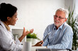 © lordn - Doctor specialist consulting a patient in a doctor's office at a clinic. Female doctor is talking with a male elderly patient.