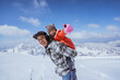 © Odua Images - father giving piggyback ride to his daughter while playing outside in the snow