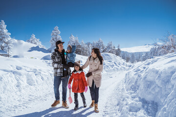 beautiful asian family walking together in landscape cover with wonderful snow