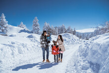 Family Walking Together In Winter With Beautiful Snow All Over The Place