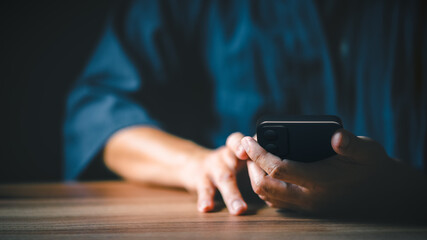 Poster - Closeup image of a man holding and using mobile phone or smartphone.