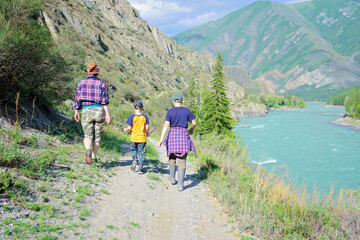 Canvas Print - Adult woman and children hiking in the mountains