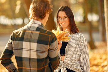 Beautiful couple spend time in a autumn park