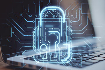 Poster - Close up of laptop computer with creative glowing padlock circuit security hologram on blurry background. Safety and web protection concept. Double exposure.