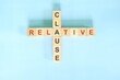 Relative clause concept in English grammar education. Wooden block crossword puzzle flat lay in blue background.