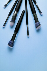 Wall Mural - Creative concept beauty fashion photo of cosmetic product make up brushes kit on blue background.